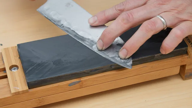 Mãos amolando a lâmina de uma faca de cozinha sobre uma pedra d'água japonesa, com a superfície molhada.