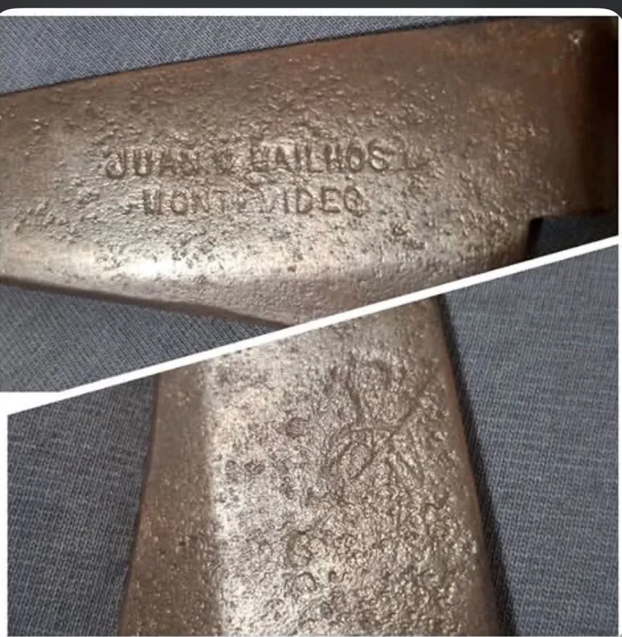 Duas fotos das folhas de uma tesoura de tosquia antiga, de aço escurecido e picado pela ferrugem: na de cima, o punção "JUAN M. MAILHOS / MONTEVIDEO" em duas linhas; na de baixo, a silhueta gasta de uma figura em pé.